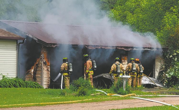 Members of the Grafton Volunteer Fire Department assess the damage and look for hot spots in the garage at 116 Wakeman Avenue in Grafton Monday afternoon. Photo by Mike Steinfeldt.