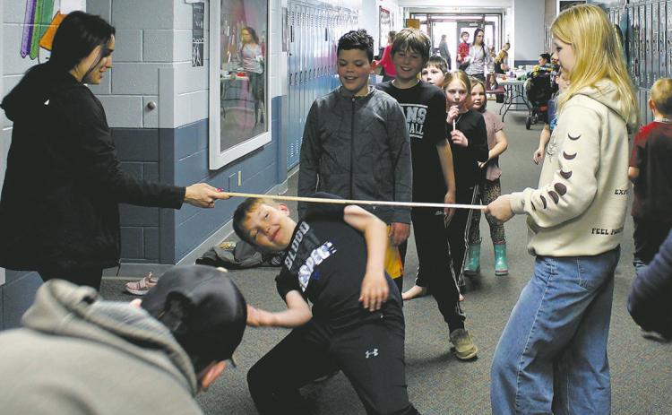 High school students helped with a limbo contest in the halls during Drayton School's family night. Photo by Jamie Rarick