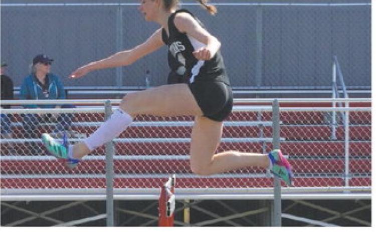 Elizabeth Fedje speeding over a hurdle at the Langdon Invitational. Photo by Larry Stokke.