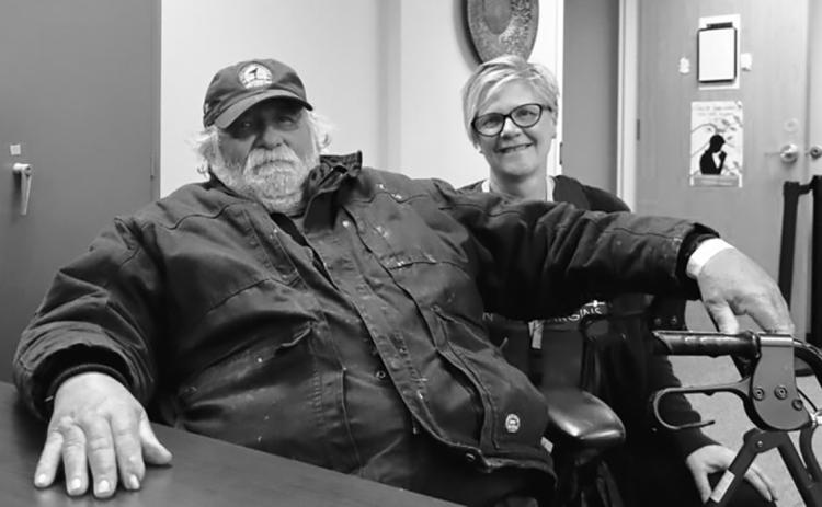 Michael Hauck, 64, left, a homeless veteran, sits next to Kris Morrissette, behavioral health manager at Ministry on the Margins in Bismarck, before being transported to a nearby hotel as he awaits approval to move into a nearby apartment on Nov. 6, 2025. (Photo by Michael Achterling/North Dakota Monitor)