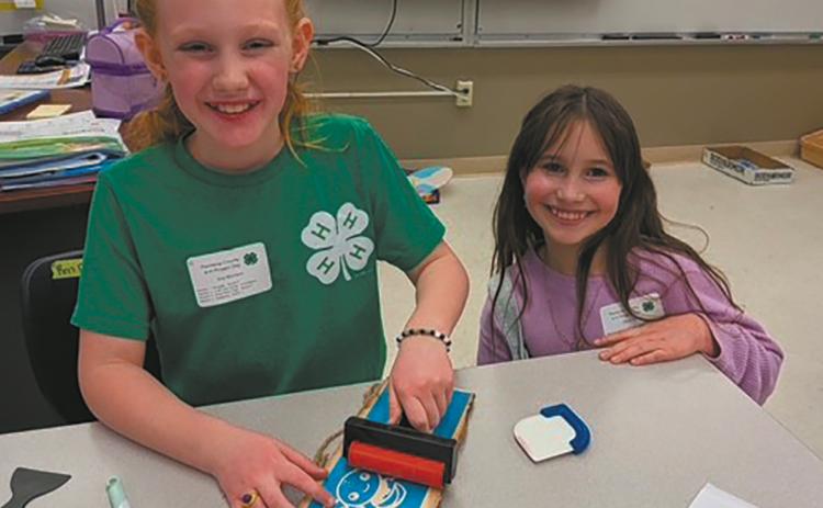 Ava and Olive personalize their signs in the sign etching class. Submitted photo