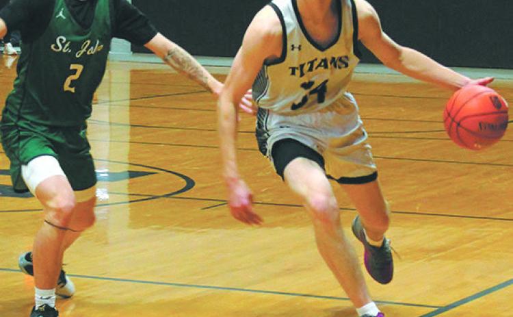 DVE's Jack Langerud moves the ball down the court past St. John's Madden Parisien.