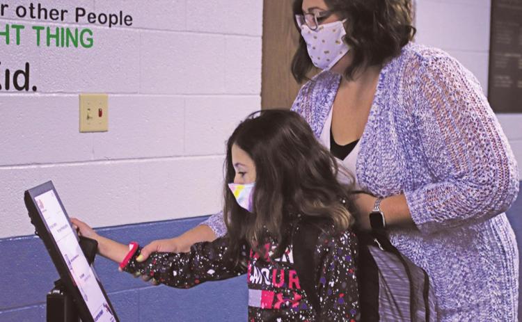 The new normal Ms. Lindsay Pollestad helps Gianna Sott take her temperature after entering school Tuesday Morning. VNV Photo by Lesa Van Camp