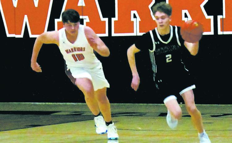 Quinn Passa breaks away from a Warrior defender to drive down the court. Photo by Jamie Rarick.