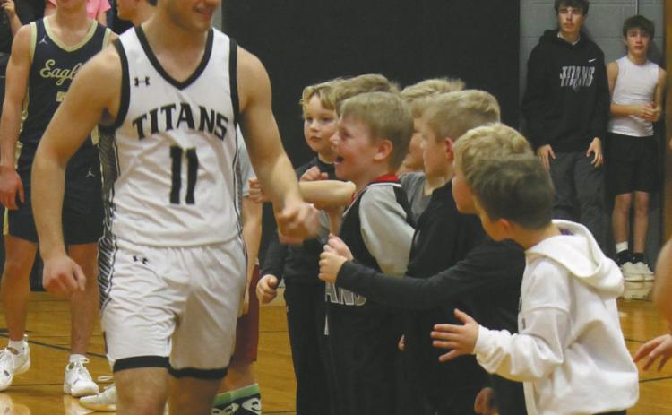 Senior Izak Feltman receives cheers from a line of Tiny Titans prior to the game against North Border. Photo by Jamie Rarick