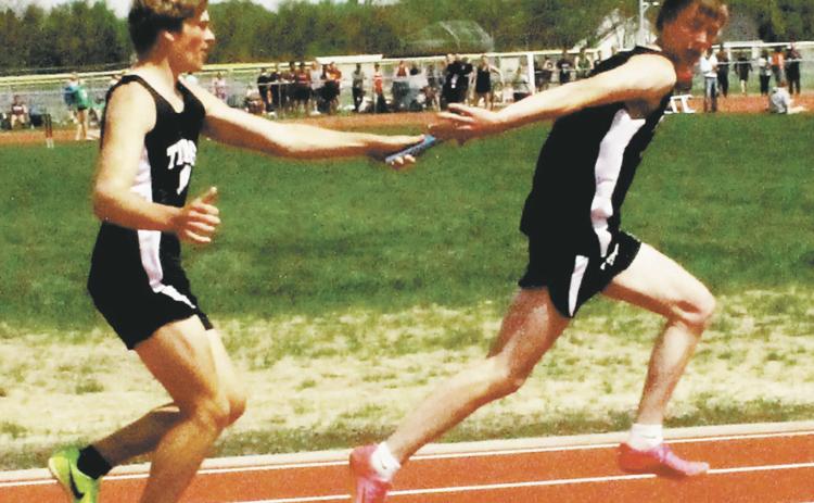 Sam Kittelson hands off to Jack Langerud in the boys 4x100 relay. The relay team, also including Mason Pollestad and Carter Johnson, finished third, qualifying for state. Photo by Jamie Rarick