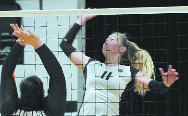 Titans sophomore Reegan Aasand jumps for the spike while Larimore defender Zoey Stone rises to attempt a block. Photo by Jamie Rarick