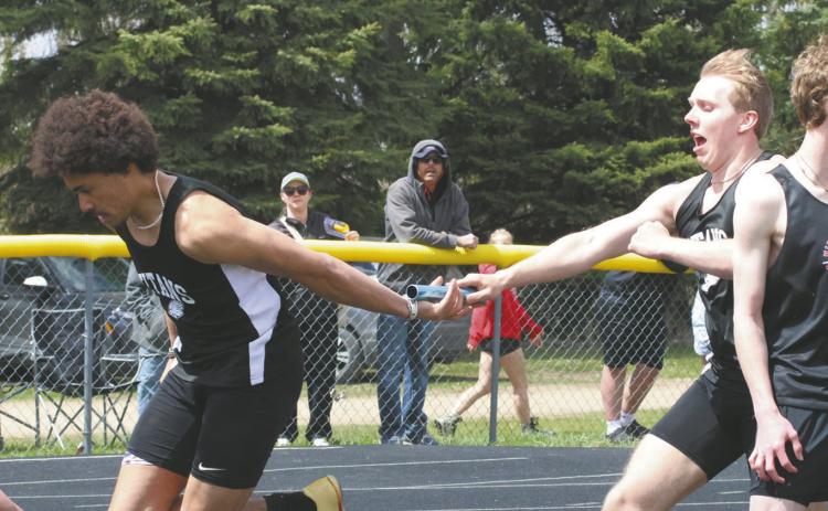 Carter Oberg hands off the baton to teammate Mason Pollestad during the Mens 4X100 Relay. Together with Carter Johnson and Trenten Keena, the relay team finished first with a time of 45.19. Photo by Jamie Rarick