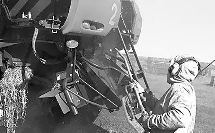 Use an air compressor to clean off debris, chaff and dirt from the combine to prevent combine fires. NDSU photo