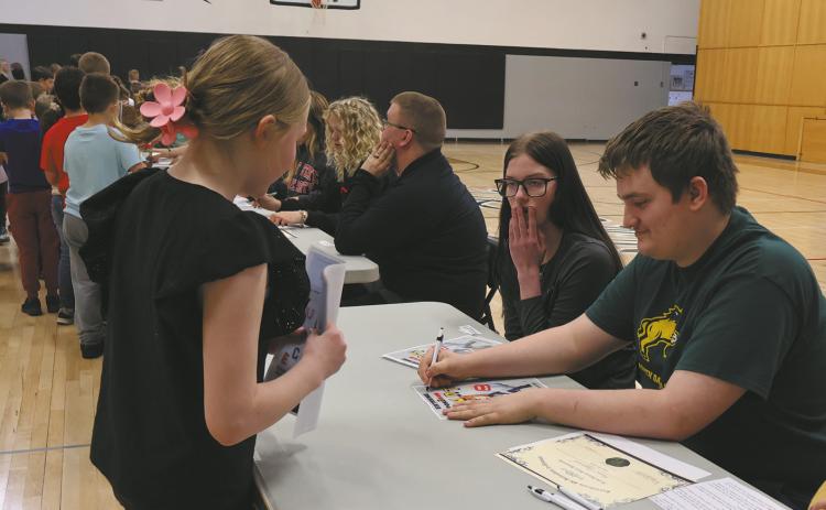 Grant Uggerud signs an autograph for an excited younger student. Photo by Rebecca Davis